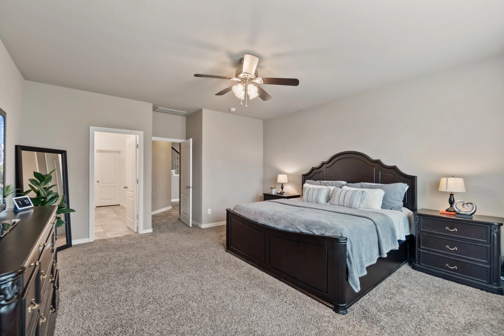 Bright neutral bedroom with dark wood bed frame and matching bedside tables